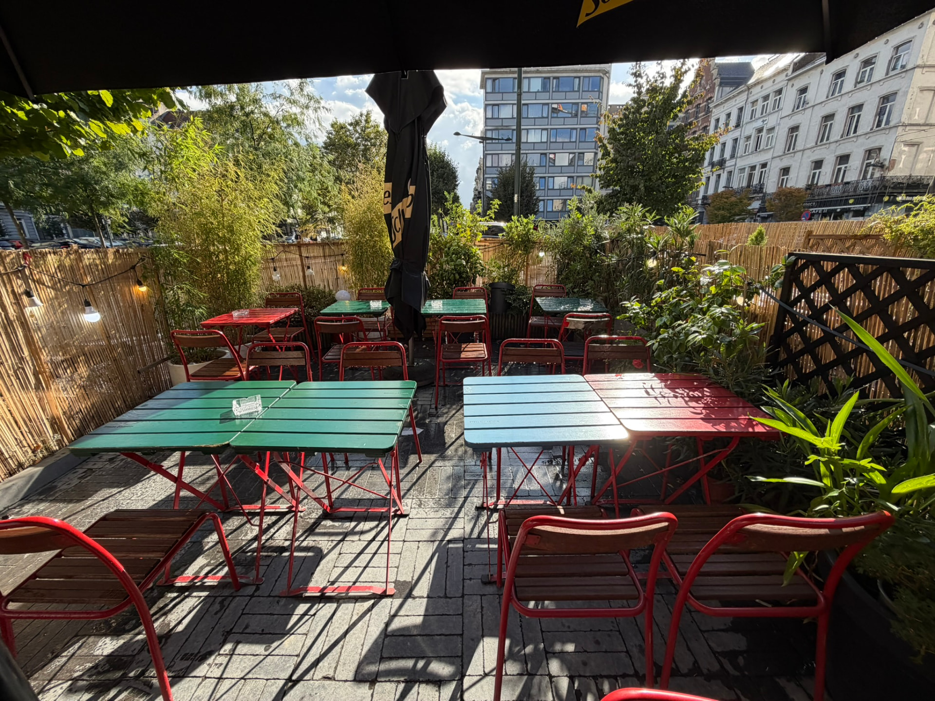 Terrasse côté jardin avec tables colorées et bambous